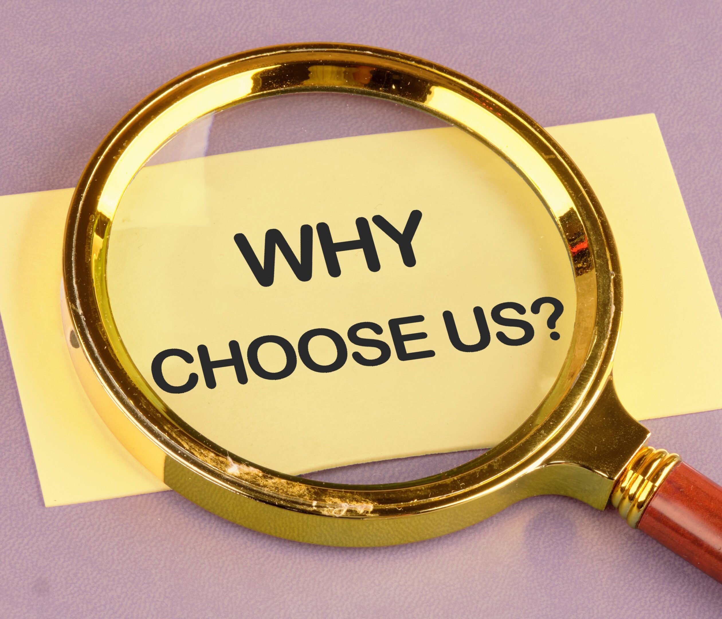 Magnifying glass highlighting the words 'WHY CHOOSE US?' on a paper.